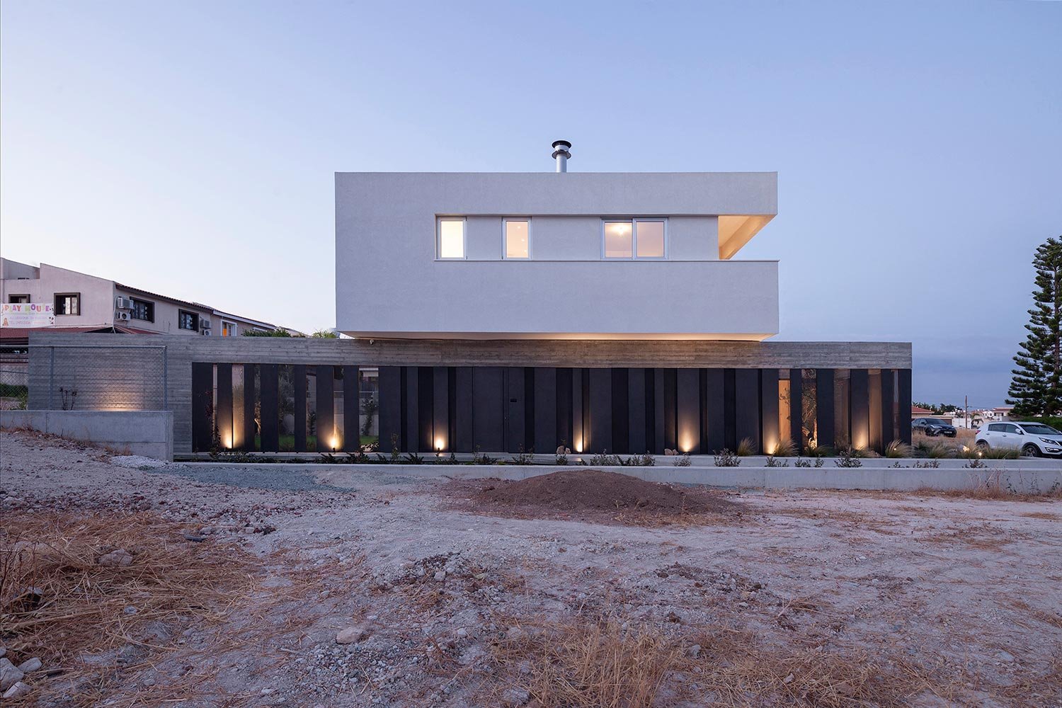 Modern house with board form concrete walls, aluminium cladding and white render volume on top